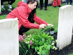 Catherine Brown, 21, one of several local residents to take part in a recent Frank Graham Cycle Liberation Tour in Europe, is the first family member to see the gravesite of her grandmother's cousin, Pte. Michael O'Neill, who was killed during the Second World War. Here, she lays a wreath at the grave as other members of the tour look on. Undated photo. (Contributed photo)