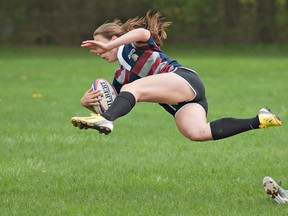 Assumption's Charlotte Thomson soars through the air after tripping over a fallen Abigail Conway of St. John's during a high school senior girls rugby match on Wednesday at the George Jones Fields. (BRIAN THOMPSON, The Expositor)