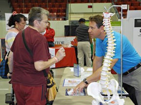 Guy Pelletier, owner of Brant Pain Relief Clinic, speaks with Mary Armstrong, one of the visitors on Wednesday to the seventh annual CARP Seniors' Resource Fair. (MICHELLE RUBY, The Expositor)