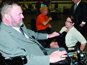 Brockville's Andrea Andrecyk talks with federal cabinet minister and Manitoba MP Steven Fletcher after his opening address at the accessABILITY 2013 Fair at St. Lawrence College on Wednesday (DARCY CHEEK/The Recorder and Times).