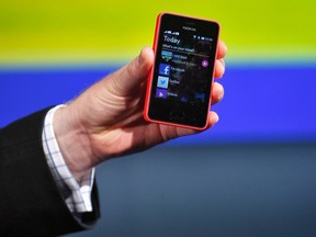 A Nokia official displays a new $99 US phone in its mid-range Asha line at a launch in New Delhi May 9, 2013. Nokia is betting low-priced phones with Internet capability will help it regain lost ground in crucial emerging markets after falling behind in the global smartphone race.  REUTERS/Anindito Mukherjee