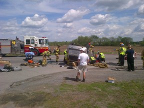 A medical transportation vehicle lays on its roof as fire crews prepare to extricate a passenger following a crash on Prince of Wales Dr. Thursday. The vehicle was carrying medical material including HIV blood samples and cryogenically frozen samples. There was no report of any damage to the samples. (CHRIS HOFLEY Ottawa Sun)