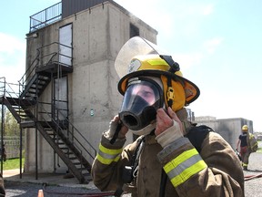Glenn Vollebregt, president and CEO of St. Lawrence College, dons firefighting equipment as he spends time with the students of the college's pre-service firefighter training program at the Loyalist Township Emergency Services training grounds.
Michael Lea The Whig-Standard