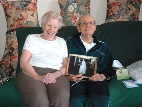 Kirsten Goruk/Daily Herald-Tribune
Antoinette and Howard deMetz, seen holding a photo from their wedding day, are celebrating their 60th wedding anniversary on May 16. Howard is 89 and Antoinette will turn 89 in August. The couple still lives at home with the aid of a nanny and some other health care professionals. The pair says the secret to a marriage lasting 60 years is tolerance.