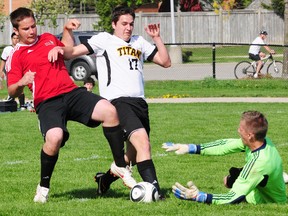Arthur Voaden goalkeeper Jarred Tuckey slides out to cover the ball against Central Elgin's Lyle Norton (17) as he battles with Viking defender Sam Heathorn in TVRA South soccer Thursday. The Titans scored late to win 1-0. (R. MARK BUTTERWICK, St. Thomas Times-Journal)