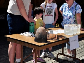 RYAN PAULSEN    Josh Ibelhauser, natural history education leader at Bonnechere Park, left, talks artifacts with park visitors Abbey and Emma Joyce and Andrea Playford on Saturday during the park's Educators Day event, where representatives from different school and community groups were invited to check out the park's many education programs on offer. For more community photos please visit our website photo gallery at www.thedailyobserver.ca.