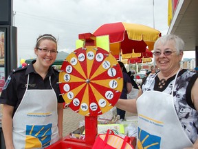 The Kincardine McDonalds hosted its annual McHappy Day on May 8, 2013 where a $1 from every Big Mac, Happy Meal and hot McCafé beverage was donated to the Ronald McDonald House in London, Ont. L to R: Colleen Craig, a volunteer from the Tivteron fire department, and Corrie LeRoy, a volunteer, helped gusts spin the wheel to win prices for a $2 donation. (ALANNA RICE/KINCARDINE NEWS)
