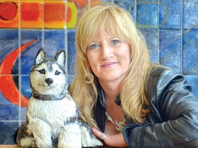 Sculptor Dawna Robertson is shown with the soapstone husky she's created for the school. (SCOTT WISHART, The Beacon Herald)