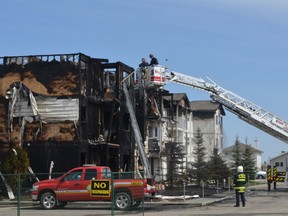 Investigators dug through the charred apartment building on Friday afternoon to determine the cause of the fire. - Thomas Miller, Reporter/Examiner