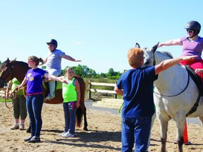 SUBMITTED PHOTO    Riders Sean O'Neill, on "Mischief", left, and Rebekka Zimmerling, astride "Wylie", do some stretching ahead of their session at the Renfrew County Therapeutic Riding Program last year. With them are volunteers Mary Flynn, far left behind the horse, Megan Terry, Cara Boyd, Jan Stewart, Kirsten Carty and Rebecca Blimkie. The program will be kicking off its second season soon, and will be hosting two volunteer clinics, on May 15 and 18, for anyone who would like to help out.