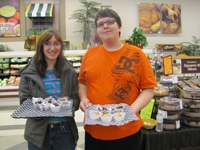 Michelle Mix and Brendan Hutchison, Grade 12 Mayerthorpe Junior Senior High School students, offer a taste of cake, enticing Mayerthorpe Co-op customers into buying the cakes in the annual fundraiser for their graduation on Saturday, May 11. The Co-op gives the grads $2 for every cakes sold.