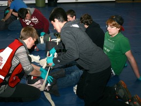 Canadian Red Cross first aid instructor Angela Boucher shows Jonathan Neniska, centre, how to wrap a splint around Curran McLeod's pretend broken leg. The first aid training was part of the Student Survival Challenge on Friday, May 11, at Beaver Brae Secondary School in partnership with Kenora Fire and Emergency Services.

GRACE PROTOPAPAS/KENORA DAILY MINER AND NEWS/QMI AGENCY