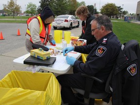 Members of East Side Pride and C-K Crime Prevention Board of Chatham-Kent assisted Sgt. Jim Lynds of the Chatham-Kent Police Service categorize outdated prescription drugs dropped off by citizens during a free campaign supported by the Ontario Association of Chiefs of Police at the Chatham courthouse on Saturday. (vicki.gough photo)