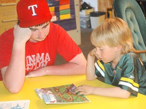 Daniel Brandt listens as Austin Young reads a book during the Homework Club program at Parkland Village School. - Brandi Morin, Reporter/Examiner