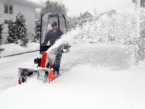 Richard Leblond uses his snowblower to clear a path on Sunday afternoon in Timmins.