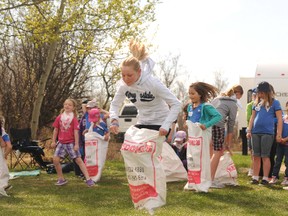 Sophia Underwood, 11, races against her fellow Girl Guide members during a friendly potato sack race at Saskatoon Island Provincial Park on Saturday. Underwood, who has been with the Wembley Girl Guides for five years, was one of hundreds of girls who came out to celebrate the Girl Guides 100th anniversary in Alberta.
KIRSTEN GORUK/Daily Herald-Tribune