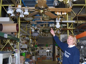Barb Ransome, ReStore manager points up to the ceiling where ceiling fans and other lighting is stored. (Sentinel-Review file photo)