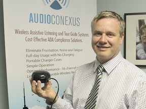 Jonathan Stanley, president and CEO of AudioConexus, holds the GPS-activated audio system that is being used on the tour trolley as it drives through Kingston. (Michael Lea The Whig-Standard)