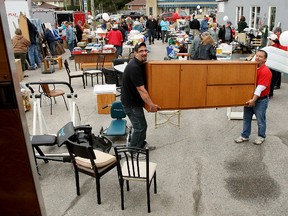 AMJ Campbell Van Lines driver John Hiscock, left, and general manager Dave Willms move a solid oak desk during the Royal LePage North Bay Real Estate Services garage sale Saturday. (MARIA CALABRESE The Nugget)
