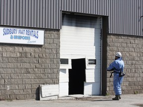 An official with the Ontario Fire Marshal's office investigates a fire at Sudbury Mat Rentals and Uniform Services at 1150 Kelly Lake Rd. Monday morning. JOHN LAPPA/THE SUDBURY STAR/QMI AGENCY