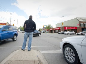 A London police officer looks checks passing cars for seatbelt and cellphone infractions at the corner of Oxford Street and Richmond Street Monday. (CRAIG GLOVER, The London Free Press)