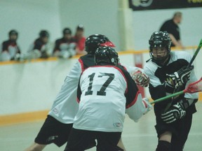 Nanton Stallions midget lacrosse player Michael Irnie, right, tries to keep control of the ball during a game against Lethbridge on Saturday.