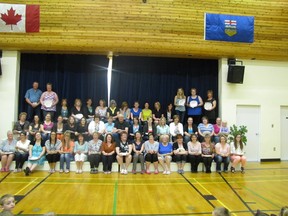 Holding their gift plates the volunteers who attended the tea pose for a photo.