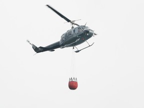 An ESRD helicopter drops water on a wildfire. DHT file photo