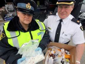 Oxford OPP Constable Stacey Culbert (left) and Inspector Tim Clark (right) show off just part of the haul of prescription drugs turned in by members of the public Saturday morning at the Canadian Tire parking lot. OPP detachments around the province hosted similar events as part of a broader effort to battle issues associated with the misuse of prescription drugs. Jeff Tribe/Tillsonburg News