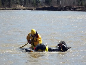 A member of the Whitecourt Fire Department attached the snowmobile of a missing snowmobiler to a rope in the Athabasca River on May 6, 2013.  
Submitted by RCMP