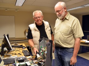 Ron Laurie, right, and Fred Rehan refurbish computers with the help of at-risk youth as part of Project Phoenix, a mentorship program. The refurbished technology is donated to families with children in need. (SARAH FERGUSON Tribune Staff)