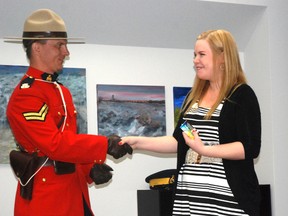 Cpl. Roy Kennedy with Grande Prairie RCMP presents Jackie Kirk with the first ticket of Crime Prevention's newly revived "positive ticket intiative" during the proclamation of Crime Prevention Week in Grande Prairie, Alberta. Kirk, a Grade 12 student in the city, does a lot of volunteer work with Crime Prevention. The initiative allows certain members in the community to honour the good work being done by youth through a ticket system that then allows them to collect prizes. May 13, 2013. KIRSTEN GORUK/DAILY HERALD-TRIBUNE/QMI AGENCY