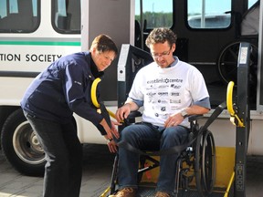 Disabled Transportation Society driver Jean McKinley helps load Home Builders Association president and chair-leader Wade Greentree into the bus outside the Eastlink Centre on Monday.  Elizabeth McSheffrey/Daily Herald-Tribune