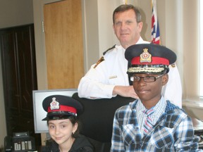 Stephanie Costa Figueiredo and Max Uhuangho pose with Chief Dennis Poole. The two Chatham children were winners of an essay contest that asked participants what they would do if they were chief of police for a day.