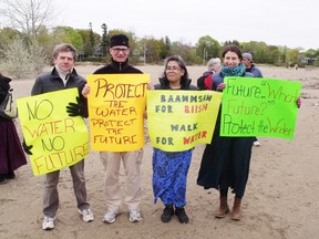 Charles Hazell, John Cameron, Valencia Root-Anoquot and Laura Robinson hold up their signs explaining why they care about our water.