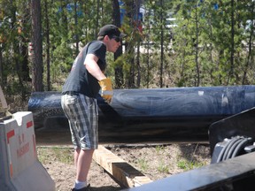 Corbin Davidson with DFI's Rycroft branch helps guide a piece of piling pipe into place for the business' booth at the Peace Regional Petroleum Show. DFI employees will be hanging out at the TEC Centre on Wednesday and Thursday to meet with people at the show, which features over 325 vendors. Grande Prairie, Alberta. Tuesday, May 14, 2013 KIRSTEN GORUK/DAILY HERALD-TRIBUNE