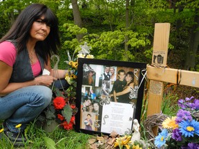 Lynn Everets lays flowers at a memorial honouring her son, Chad, in this Simcoe Reformer photo from May 2013. Chad was struck and killed on Cockshutt Road in 2011 following a Friday the 13th motorcycle rally in Port Dover. Police are still looking for the person responsible for his death.  (SARAH DOKTOR Simcoe Reformer)