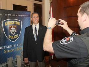 Const. Steve Koopman, right, takes a picture of the new police chief, Gilles Larochelle, for the department. The constable has been making more and more use of social media websites to help solve crimes and interact with the community. (Michael Lea The Whig-Standard)
