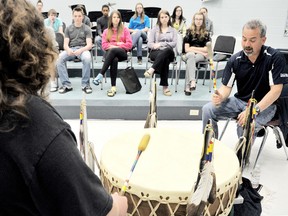 Luke George, of Kettle Point, keeper of the Zhowske Miingan (Blue Wolf) drum performs a healing song with Brennan Ireland, left, for students during the 2013 Youth Cultural Symposium   at John McGregor Secondary School Tuesday, May 13, 2013 in Chatham, On. DIANA MARTIN/ THE CHATHAM DAILY NEWS/ QMI AGENCY