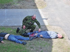 First responder Cpl. Jason Rodrigue tends to a pair of casualties, played by Wes Rumpell, left, and Pte. Jason O’Hearn, during an emergency preparedness exercise on Tuesday morning, part of the annual inspection process at CFB Petawawa’s ammunition platoon.