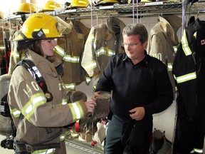 Fire Chief for the day Katie Capel tries on firefighter gear with the help of County of Brant fire prevention officer Jeff Balkwill at the Paris firehall on Monday during a tour. Katie was one of nine Paris District High School students chosen by school staff and students to be honoured by the Paris Optimist Club on Youth Appreciation Day. MICHAEL PEELING/The Paris Star/QMI Agency