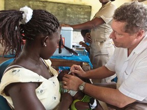 Chief executive of the Global Alliance for Vaccines and Immunisation (GAVI), Seth Berkley, vaccinates a child with a Rotavirus vaccine at the Nkyenoa health outreach point in the village of Nkyenoa April 27, 2012.  REUTERS/GAVI/2012/Olivier Asselin/Handout