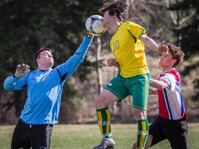 Canmore Collegiate Crusaders striker John Lee, centre, tries to get the ball past a Strathmore Spartans keeper during a Foothills Athletic Senior Boy's Varsity soccer game in Canmore on Wednesday, May 8, 2013. Justin Parsons/ Canmore Leader/ QMI Agency