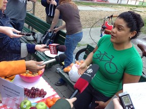Natalia Martinez speaks to the media while handing out free fruit to people in front of Toronto City Hall on Wednesday, May 15, 2013. The "illegal" pop-up food cart was organized by Food Forward to draw attention to the city's antiquated street food rules. (Don Peat/Toronto Sun)