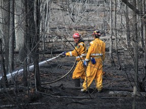 Firefighters continue to work to contain the wildfire. Postmedia File Photo.