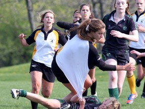 Nicolle Gaudet of the La Salle Black Knights gets hauled down by her jersey by Holy Cross Crusaders’ Mikala Wheeler during a high school girls rugby semifinal game at La Salle on Wednesday. The Knights won 17-7. (Ian MacAlpine/The Whig-Standard)