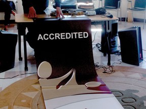 Medical director A. J. White unfurls the banner from Accreditation Canada in the healing room of Whitefish Bay’s newly accredited medical centre.