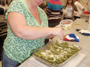 Amanda Mueller puts the finishing touches on a dish of asparagus that she and other participants made during the Cooking without the Box workshop on Monday at St. Paul's United Church. 

KRISTINE JEAN/TILLSONBURG NEWS/QMI AGENCY