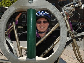 Kathleen Lowe, of Brockville's cycling advisory committee, places her bicycle by one of the bike parking rings placed on King Street to lure more cyclists downtown. RONALD ZAJAC The Recorder and Times