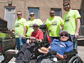 Brantford Power employees Craig Branton (left), Domenic D'Amato, Jim Ray and Steve Faulkner are part of a crew cooking hamburgers during a fundraising barbecue on Thursday at 84 Market St.  Funds raised go to Participation House, represented by clients Paul Benoit and Mike Warner (right).(Brian Thompson, The Expositor)